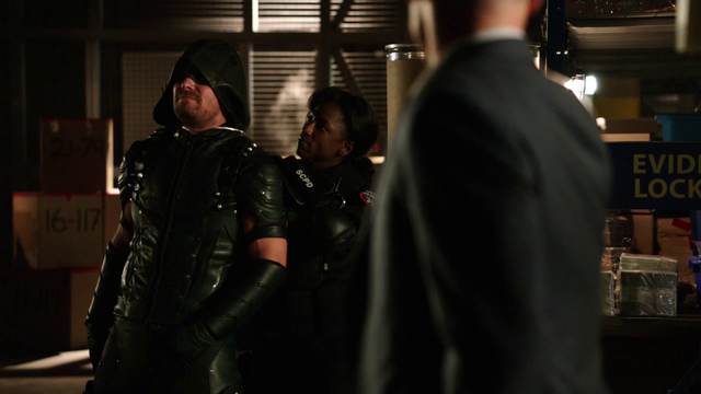 File:Lance watches as Liza Warner holds the Green Arrow hostage.png