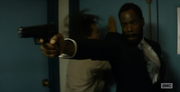 Nick tries to break down the security door while Strand shoots at the horde and misses