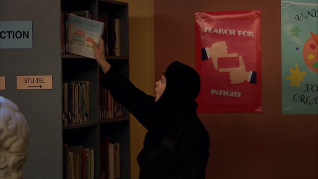 File:Season 1, Episode 2 - Wendell sneaking book on shelf.png