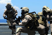 U.S. Navy Members Of Explosive Ordnance Disposal Mobile Unit (EODMU) 11, Platoon 0-2, Take Their Positions On The Flight Deck Of The Aircraft Carrier USS Ronald Reagan During A Fast Roping Exercise