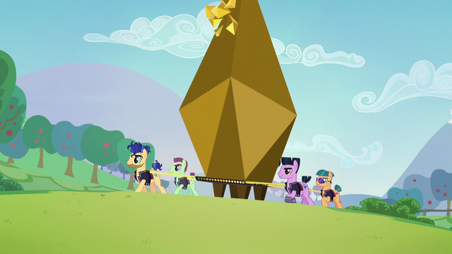 File:Backup dancers lifting a giant bronze capsule S5E24.png
