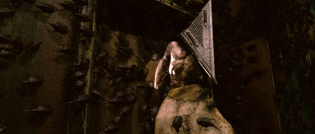 File:Pyramid Head as he retreats as Cybil shoots his hand..jpg
