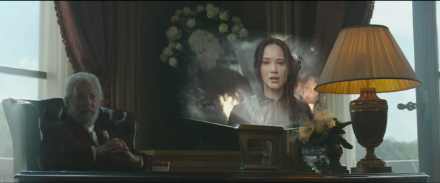 Archivo:Snow viendo la propo de Katniss en el Distrito 8.png