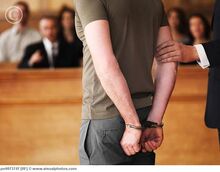 Handcuffed man standing in courtroom pe0073747